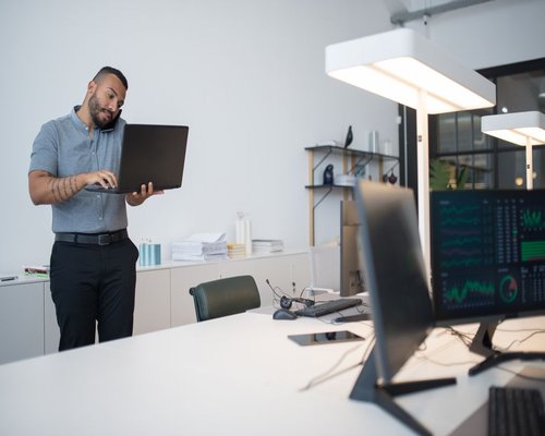 Person adjusting monitor settings in a modern office